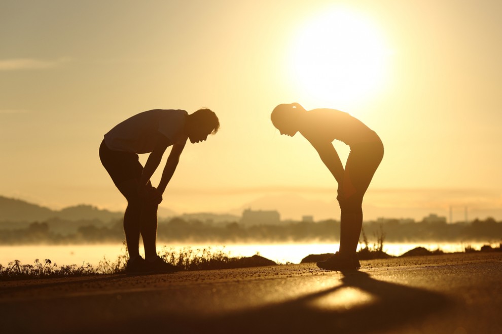 two athletes after exercising who are exhausted and trying to recover