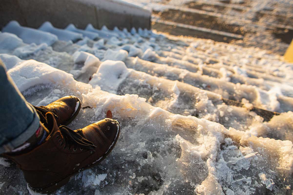 walking safely down ice and snow covered steps