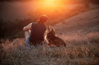 Empty Nest Woman enjoying the sunset with her dog